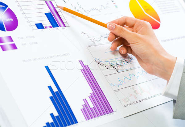 female hand pointing pencil on financial charts Stock photo © adam121