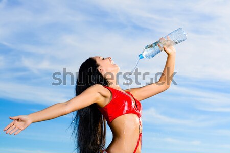 Stock photo: sport girl in red uniform with a bottle of water