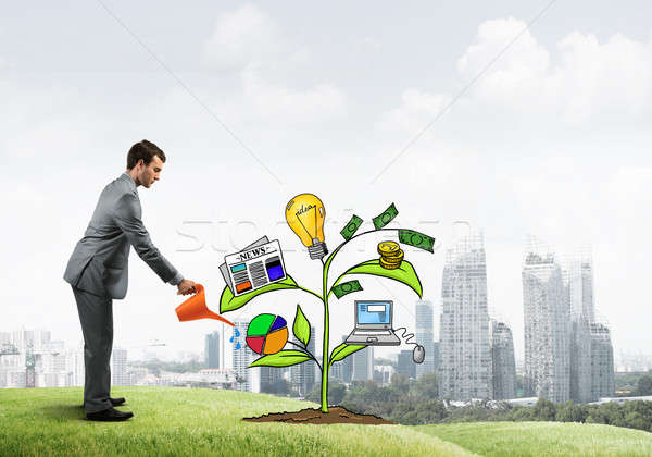 Young businessman outdoors watering drawn growth concept with can Stock photo © adam121