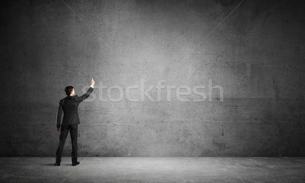 Stock photo: Businessman draw on concrete wall