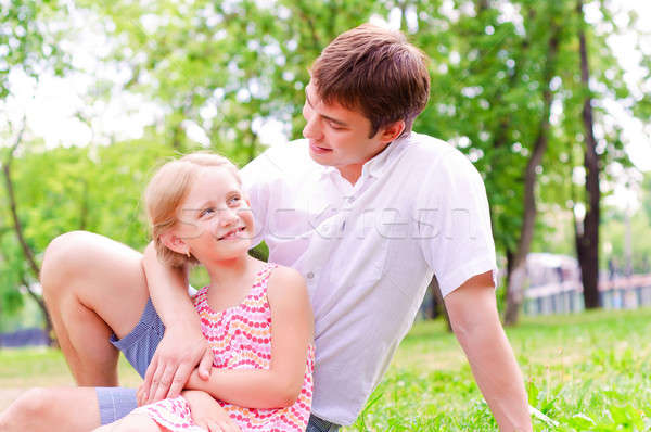 Father and daughter sitting together on the grass Stock photo © adam121
