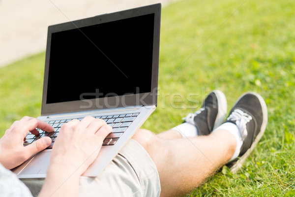 Młody człowiek pracy parku laptop posiedzenia trawy Zdjęcia stock © adam121