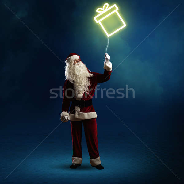 Santa Claus is holding a shining gift Stock photo © adam121