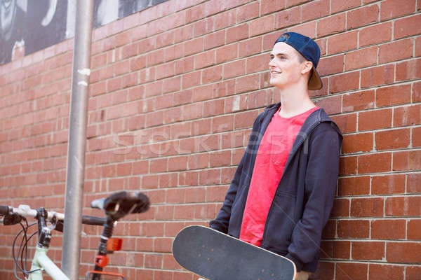 Stock photo: Handsome guy with skateboard