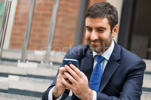 Biznesmen przystojny posiedzenia schody telefonu komórkowego Zdjęcia stock © adam121