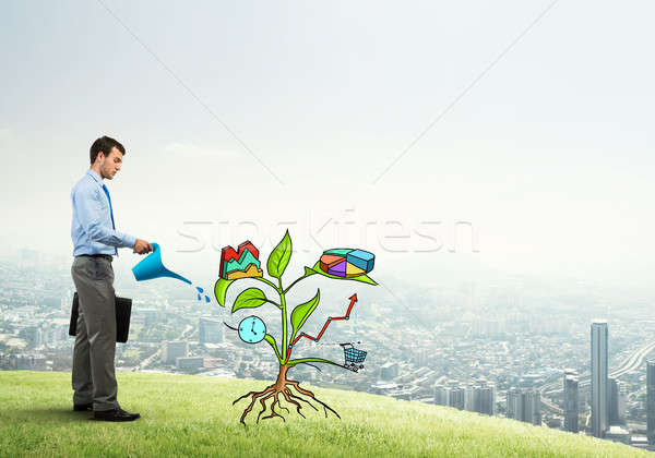 Young businessman outdoors watering drawn growth concept with can Stock photo © adam121