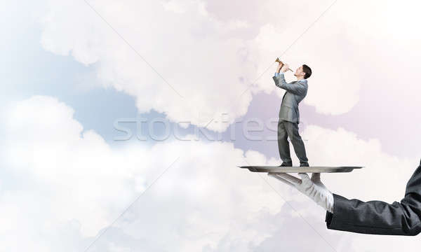 Businessman on metal tray playing fife against blue sky background Stock photo © adam121