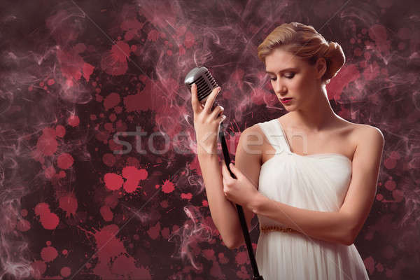 Atrakcyjna kobieta piosenkarka mikrofon za streszczenie moda Zdjęcia stock © adam121