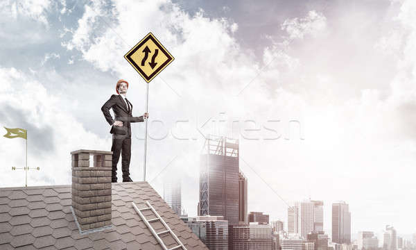 Stock photo: Mister boss on brick roof with sign in hands. Mixed media