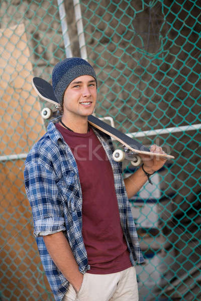 Stock photo: Handsome guy with skateboard