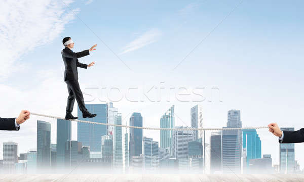 Stock photo: Business concept of risk support and assistance with man balancing on rope