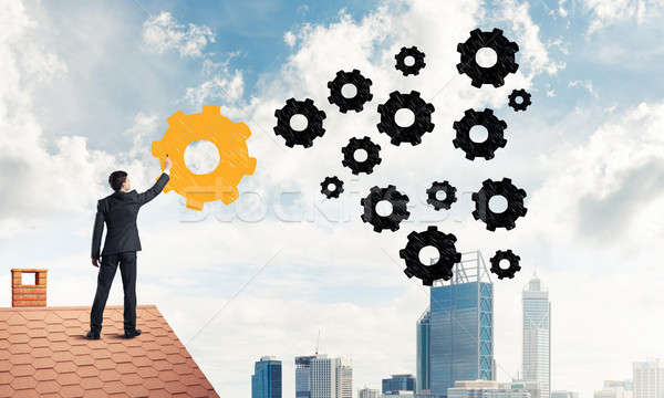 Businessman standing with back on house brick roof and drawing.  Stock photo © adam121