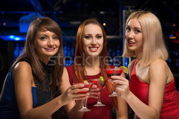 three girls raised their glasses in a nightclub Stock photo © adam121