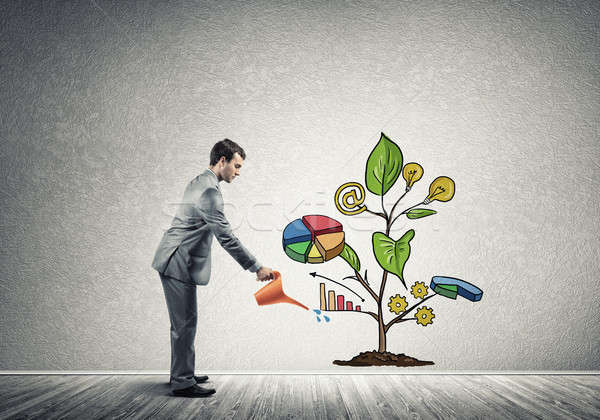 Young businessman in empty room watering drawn growth concept wi Stock photo © adam121