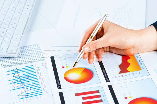 Stock photo: female hand pointing to the financial growth chart