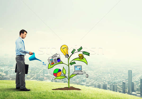 Young businessman outdoors watering drawn growth concept with can Stock photo © adam121