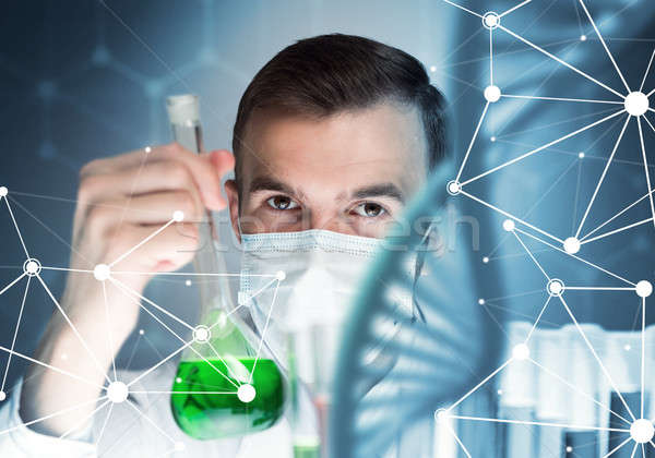 Young scientist mixing reagents in glass flask in clinical laboratory Stock photo © adam121