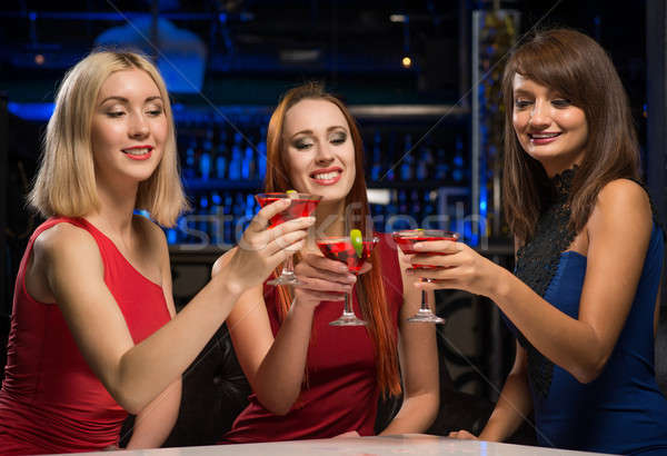 three girls raised their glasses in a nightclub Stock photo © adam121