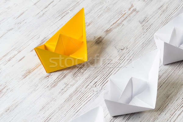 Business leadership concept with white and color paper boats on wooden table Stock photo © adam121