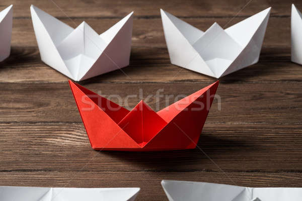 Stock photo: Business leadership concept with white and color paper boats on wooden table