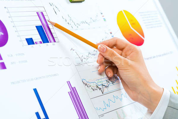 female hand pointing pencil on financial charts Stock photo © adam121