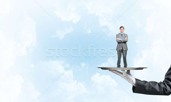 Confident businessman presented on metal tray against blue sky background Stock photo © adam121