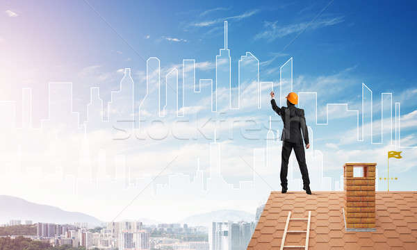 Man architect draw silhouette of modern city on blue sky. Mixed media Stock photo © adam121