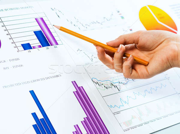 female hand pointing pencil on financial charts Stock photo © adam121