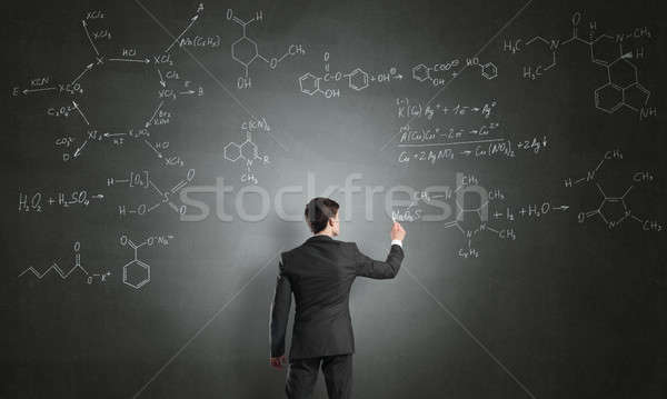 Cientista escrita fórmulas quadro-negro moço terno Foto stock © adam121