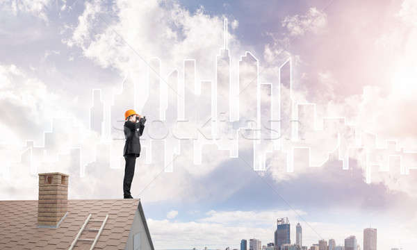 Engineer man standing on roof and looking in binoculars. Mixed media Stock photo © adam121