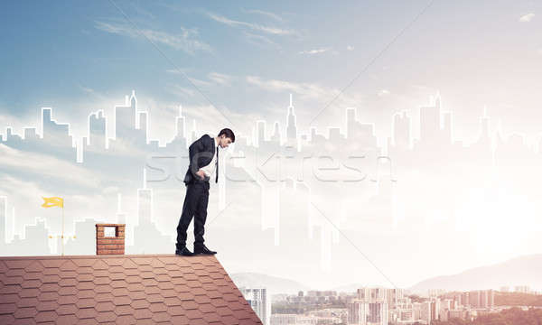 Zakenman naar beneden te kijken dak moderne stadsgezicht jonge Stockfoto © adam121