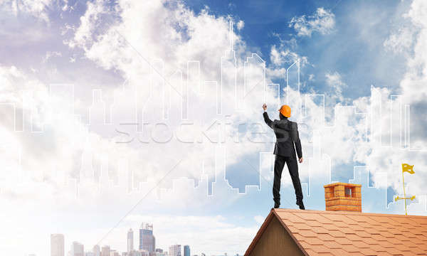 Man architect draw silhouette of modern city on blue sky. Mixed media Stock photo © adam121