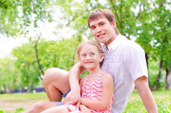 Father and daughter sitting together on the grass Stock photo © adam121