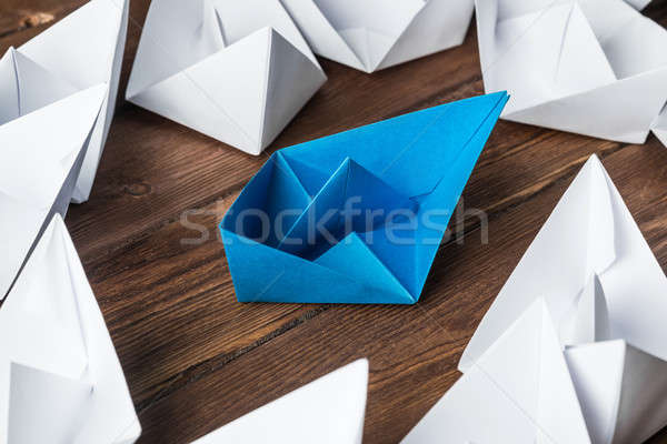 Business leadership concept with white and color paper boats on wooden table Stock photo © adam121