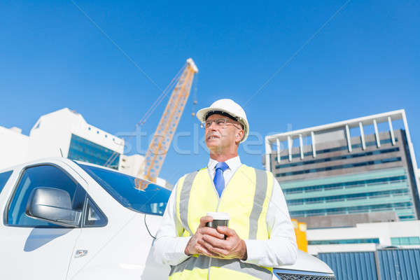 Engineer builder on construction site at sunny day with coffee in hand Stock photo © adam121