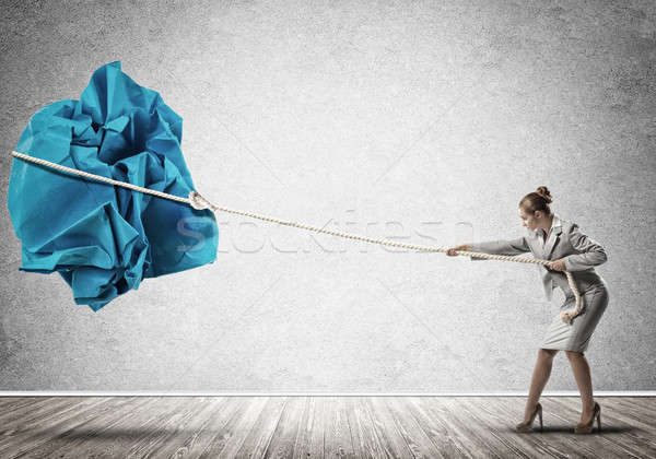 Woman pulling with effort big crumpled ball of paper as creativity sign Stock photo © adam121