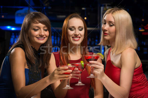 three girls raised their glasses in a nightclub Stock photo © adam121