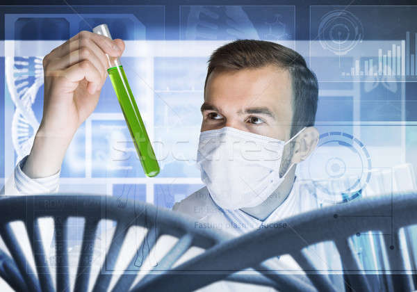 Stock photo: Young scientist mixing reagents in glass flask in clinical laboratory