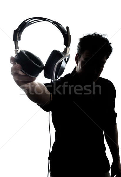 Stock photo: Male in silhouette showing headphones