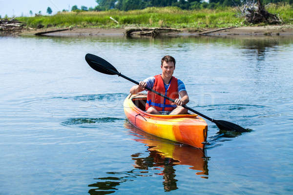 Man With Safety Vest Kayaking Alone on a Calm River Stock photo © aetb
