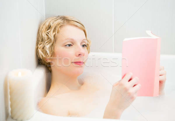 Happy young woman relaxing and reading a book in the bath Stock photo © aetb