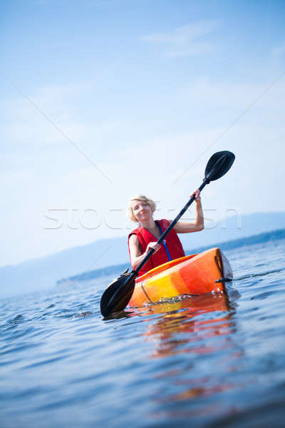 Woman With Safety Vest Kayaking Alone on a Calm Sea Stock photo © aetb