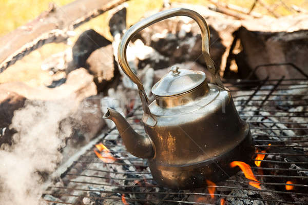 Stock photo: Kettle with water heated on the fire