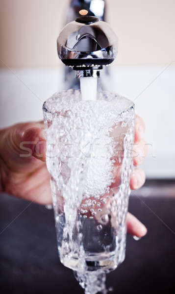 Very thirsty man filling an overflowing glass of water Stock photo © aetb