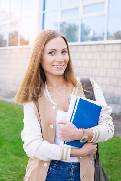 Student standing with books on building background Stock photo © Agatalina