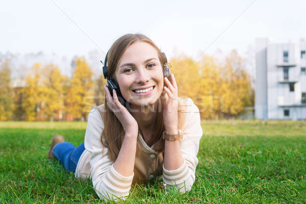 Student listening to headphones and smiling at camera Stock photo © Agatalina
