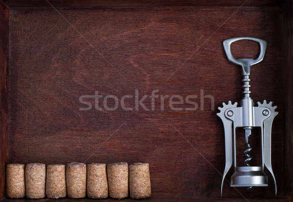 Corkscrew and a row of identical wine corks into dark box Stock photo © Agatalina