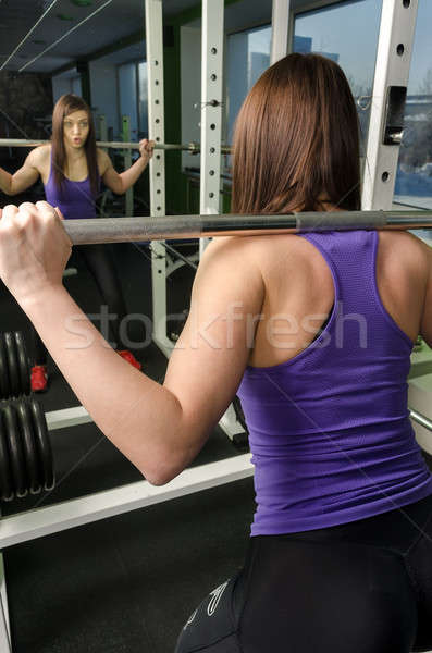 Woman doing shoulder exercise with weight bar Stock photo © Aikon