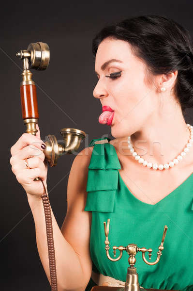 Attractive woman showing tongue into phone Stock photo © Aikon
