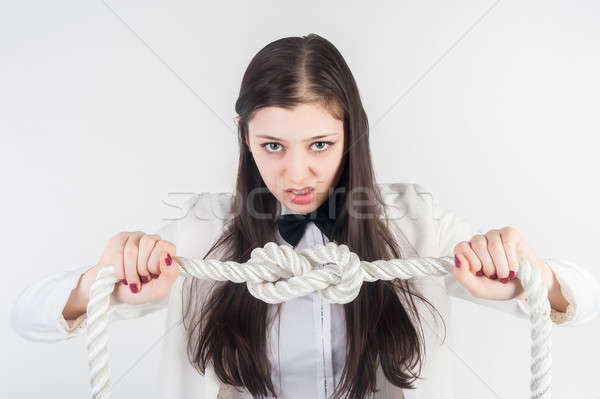 Angry businesswoman knots on rope. Problem concept Stock photo © Aikon